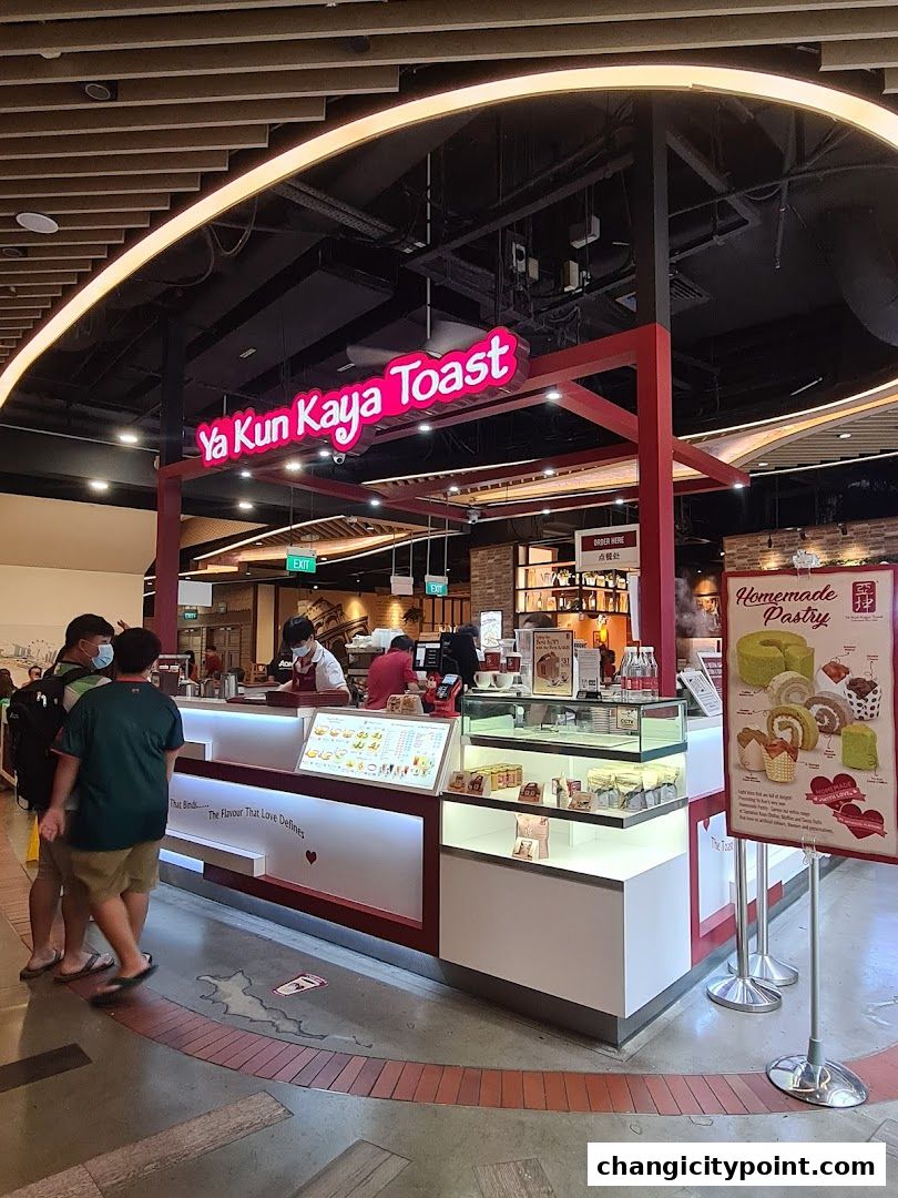 Ya Kun Kaya Toast shop with staff serving customers and displaying pastries.