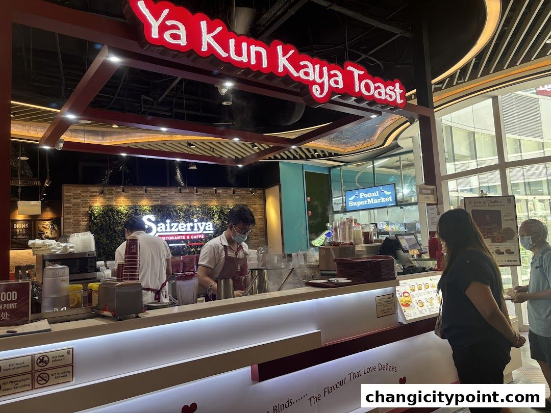 Ya Kun Kaya Toast shop counter with staff preparing orders and customers waiting.