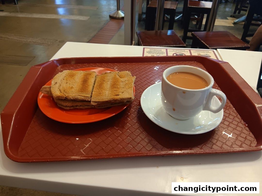 A tray with kaya toast and a cup of milk tea from Ya Kun Kaya Toast.