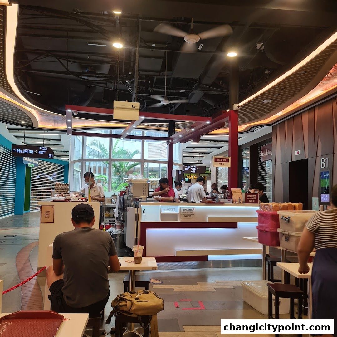 Interior view of Ya Kun Kaya Toast with staff serving customers and food items on display.