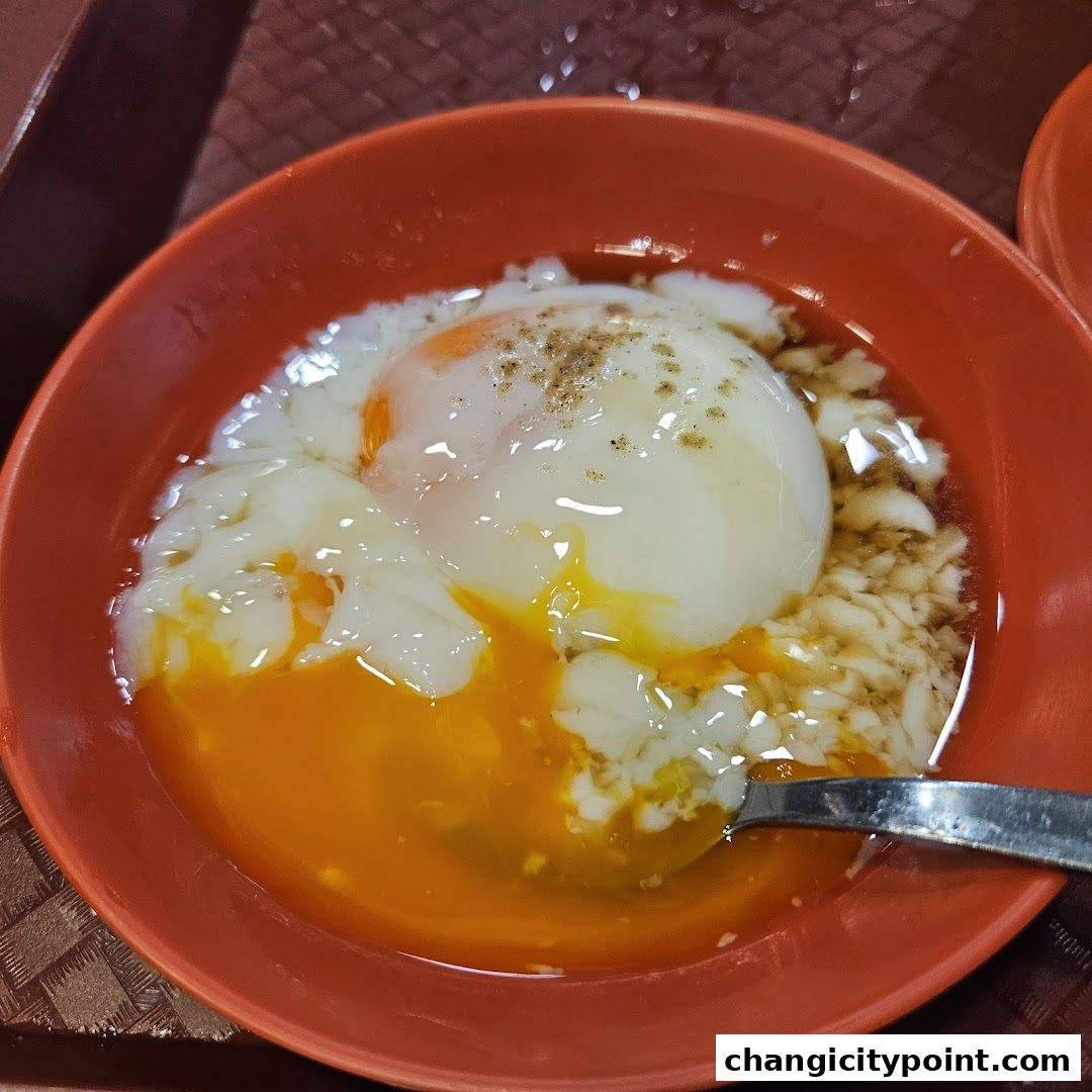 A close-up shot of two soft-boiled eggs in a bowl with soy sauce and pepper.
