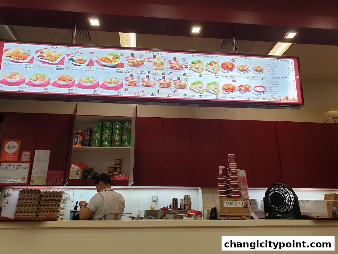 A brightly lit menu board displaying various Asian signature sets, toastwich sets, and beverages.