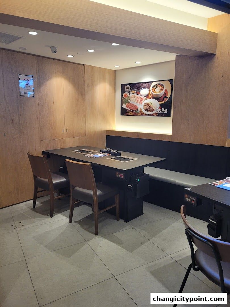 Interior of a Yakiniku restaurant with tables, chairs, and a food display.