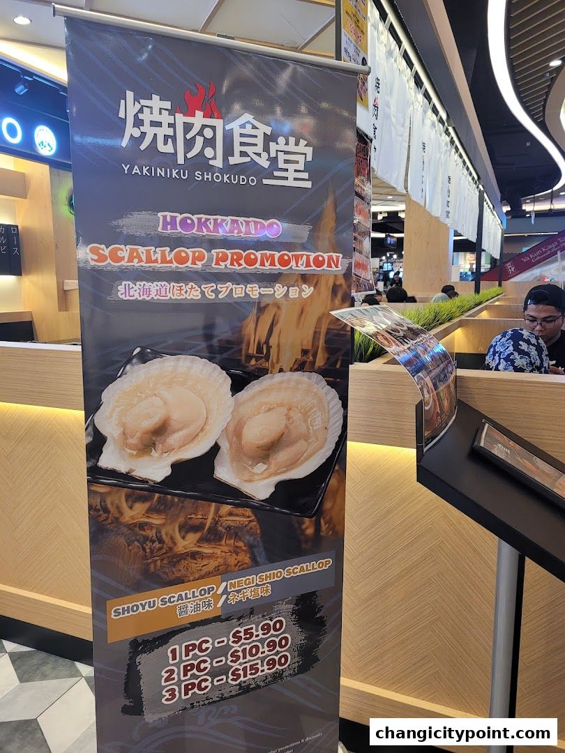 A promotional banner for Hokkaido Scallop at Yakiniku Shokudo, featuring prices.