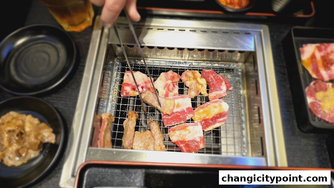 Close-up of raw and grilling yakiniku meat on a barbecue grill.