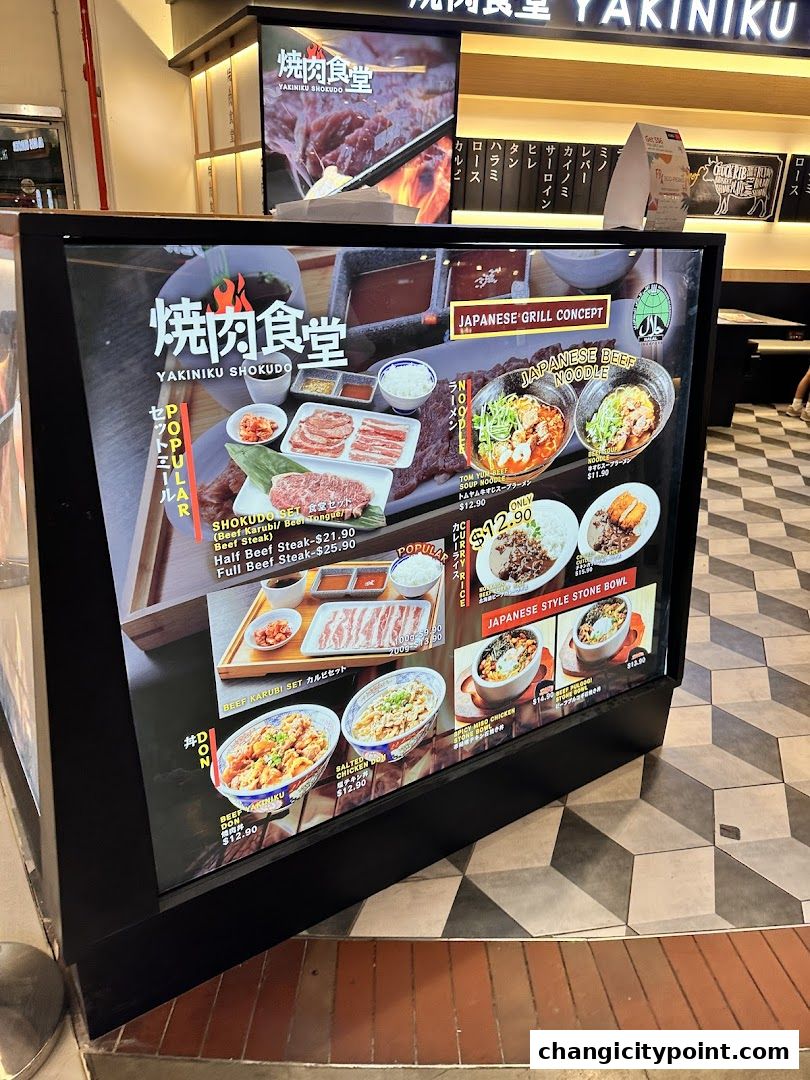 A digital menu board displays various Japanese yakiniku dishes and noodle bowls.