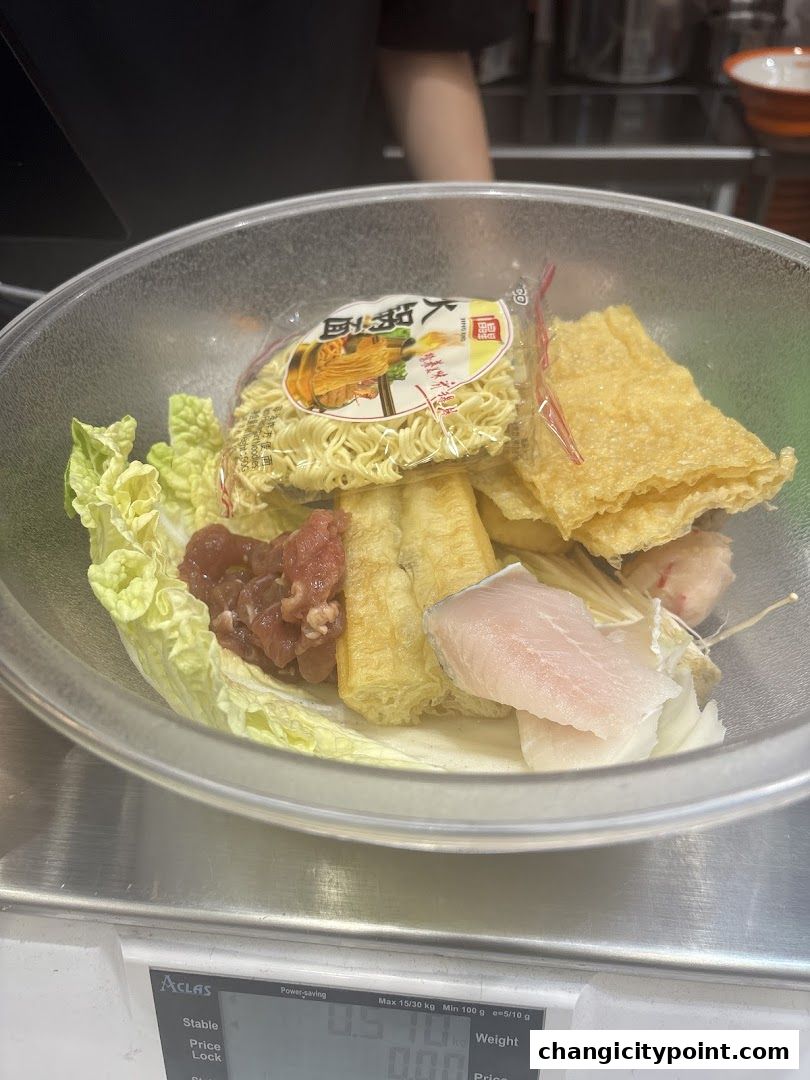 A bowl of ingredients for Mala Tang, including noodles, meat, fish, and vegetables, on a scale.
