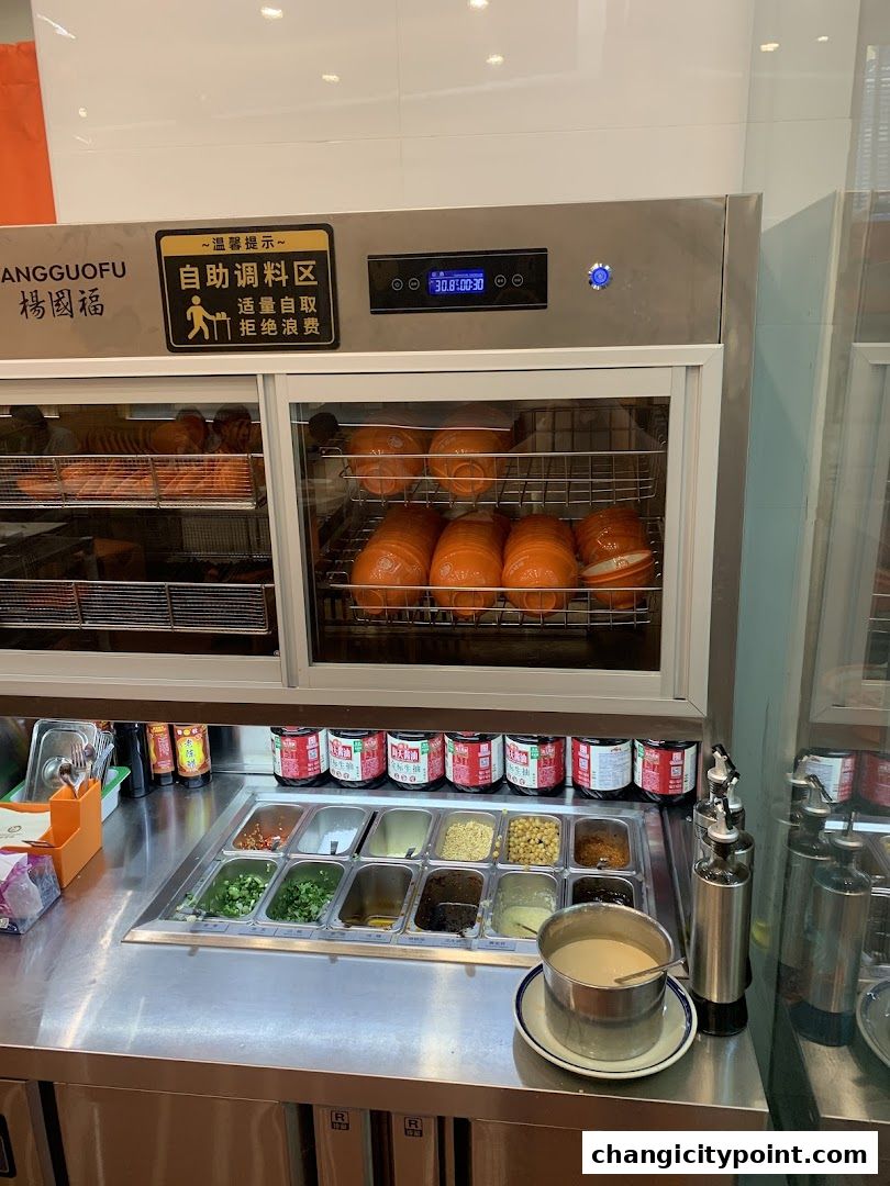 Self-serve condiment station with various sauces and toppings at Yang Guo Fu Mala Tang.