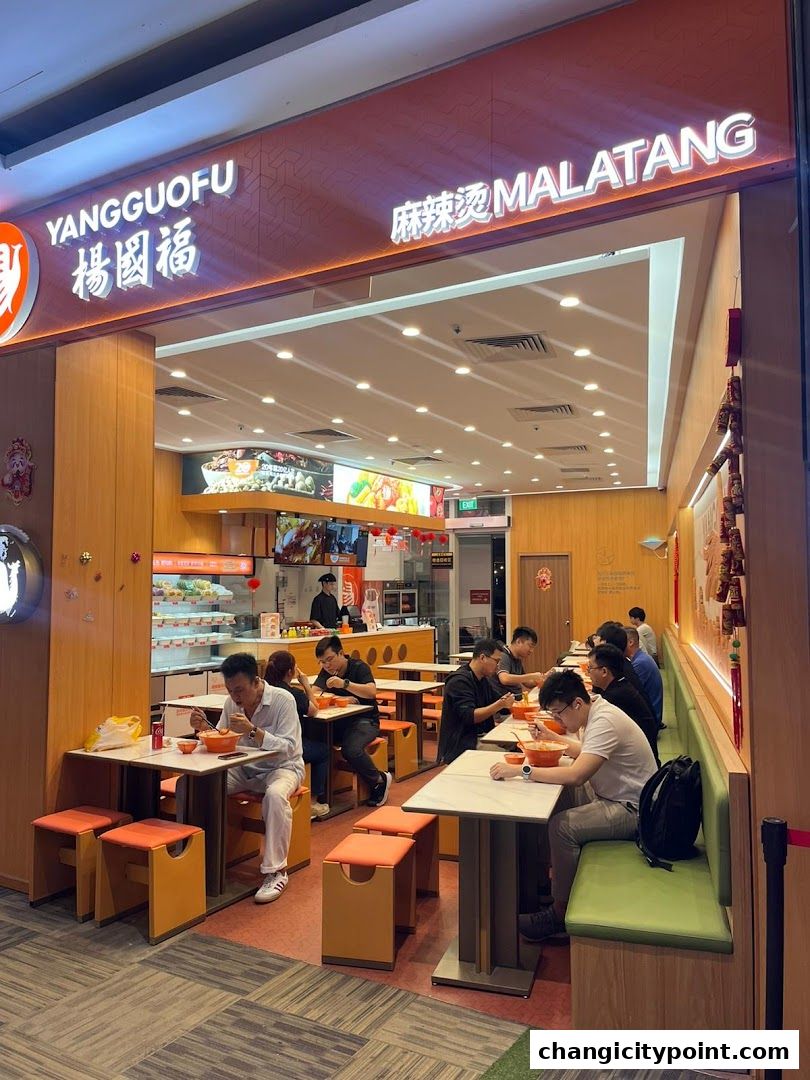People dining at Yang Guo Fu Mala Tang restaurant with a visible counter and seating.