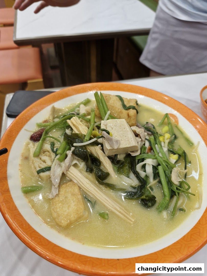 A bowl of Mala Tang with various ingredients in a creamy broth.