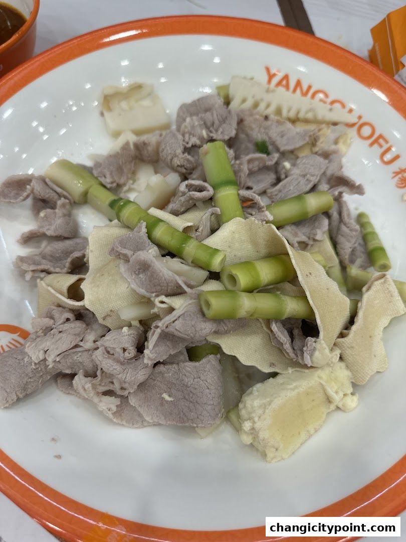 A bowl of Mala Tang with thinly sliced meat, bamboo shoots, and tofu skin.