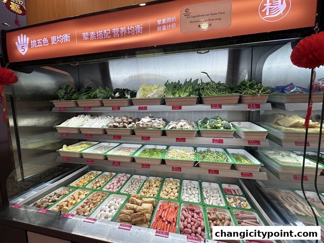 A display of fresh ingredients for Mala Tang, including vegetables, mushrooms, and meats.